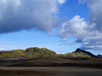Grüne Berge erheben sich über der Ascheebene - Hochland